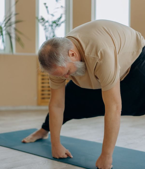 Person practicing gentle yoga movements in a dark atmospheric room